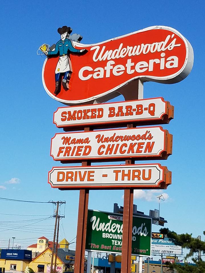 Tall roadside pole sign photographed against a blue sky